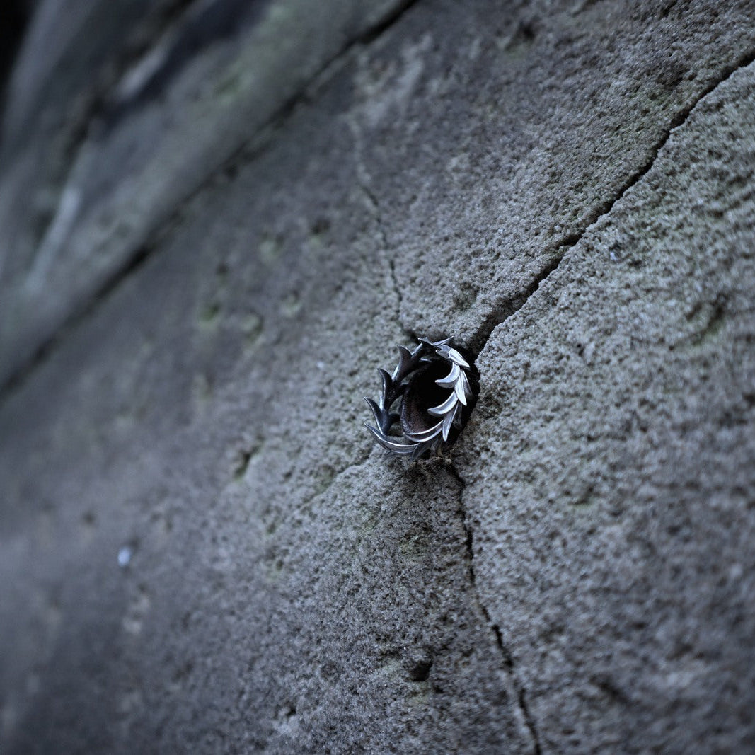 A small black and white bird, likely a chickadee, perched on a textured gray concrete surface.