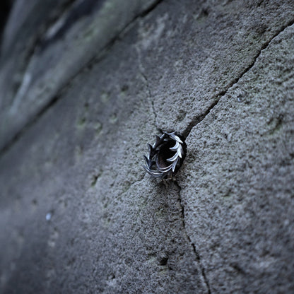 A small black and white bird, likely a chickadee, perched on a textured gray concrete surface.